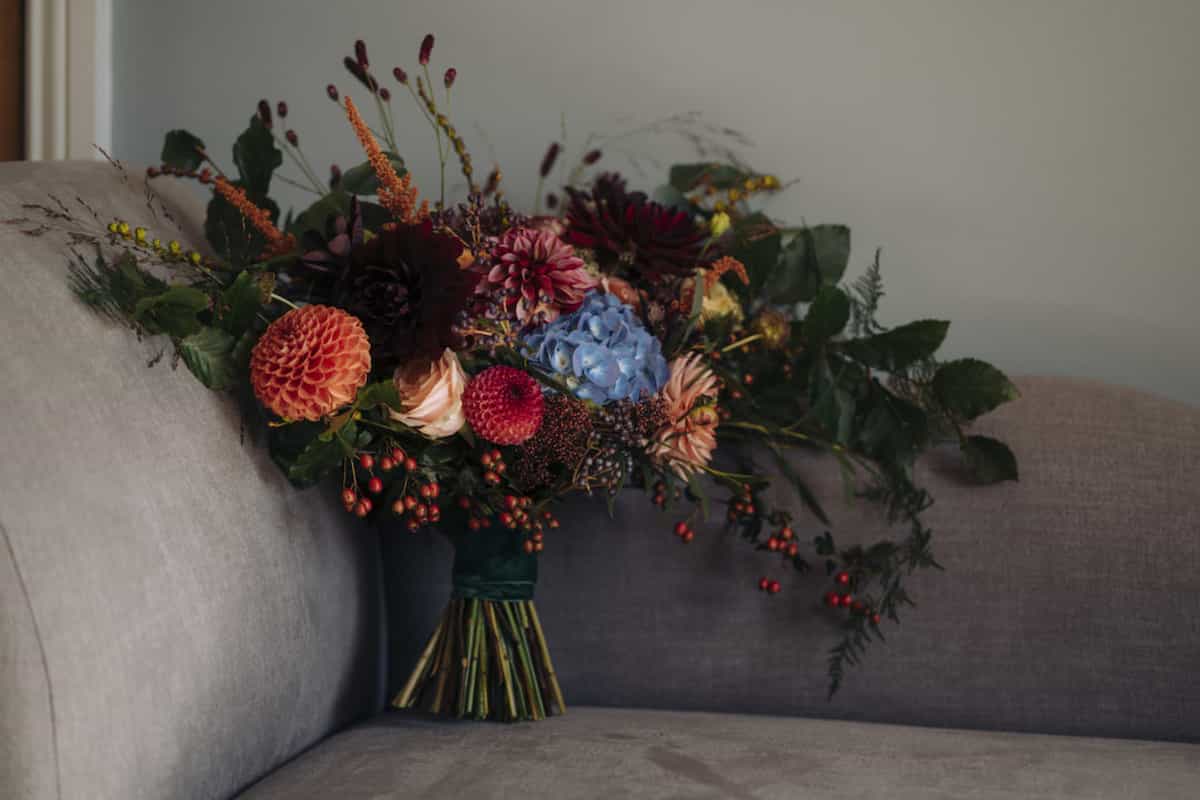 A very colourful bridal bouquet standing on a sofa