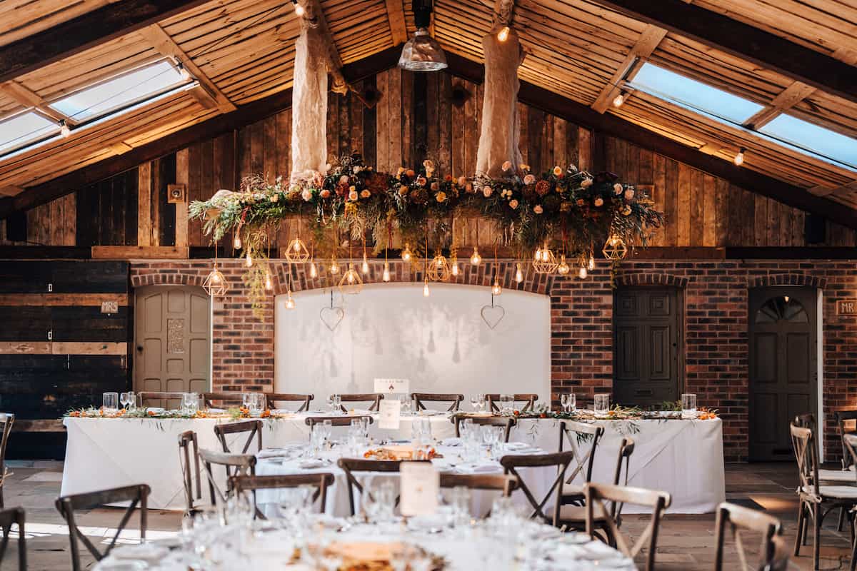 A floral arrangement above a table in a rustic barn