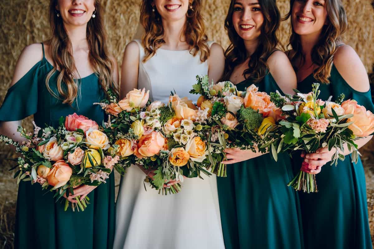 A bride and bridesmaids holding pink and yellow bouquets