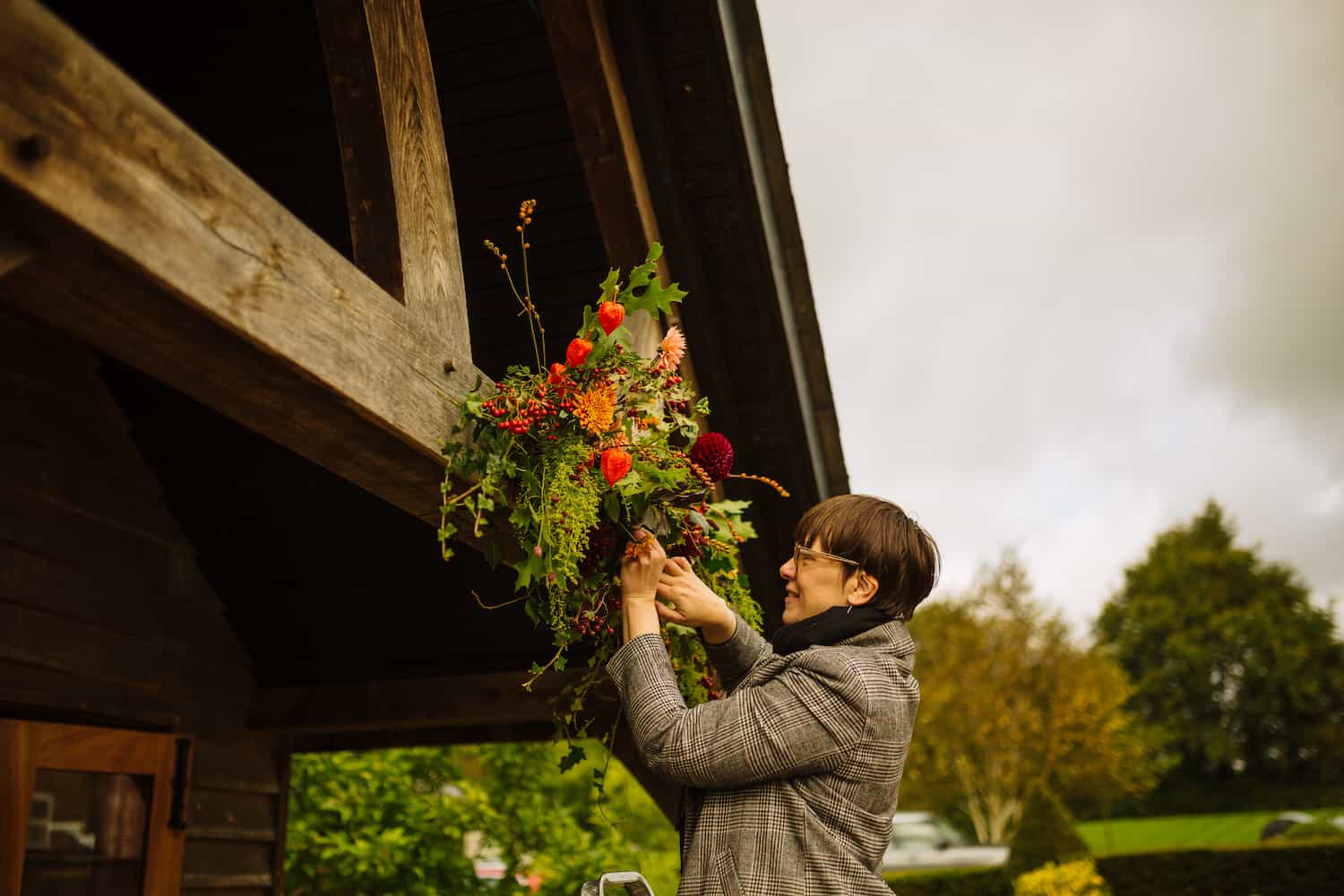 Laura building a floral display on a wedding venue porch